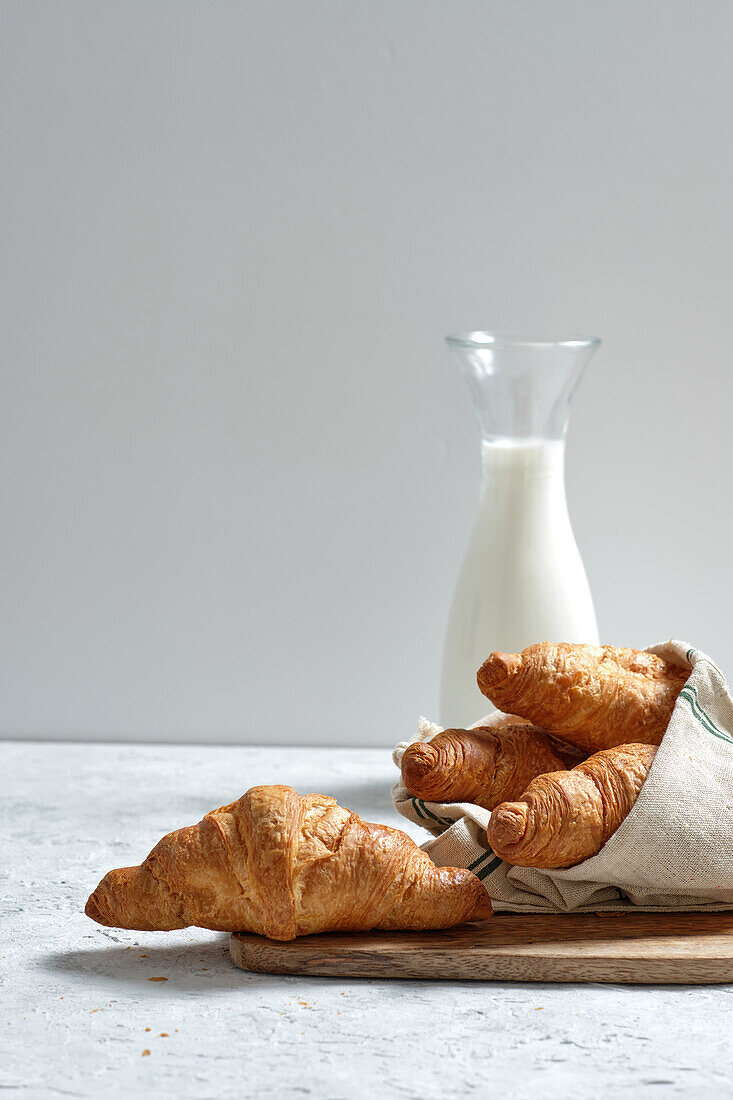 Leckere Croissants und eine Flasche Milch auf dem Frühstückstisch in der Küche