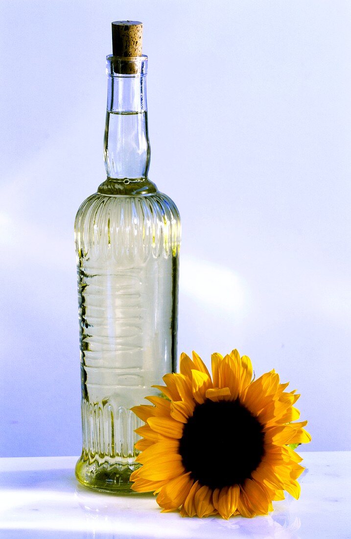 A bottle of sunflower oil and sunflowers
