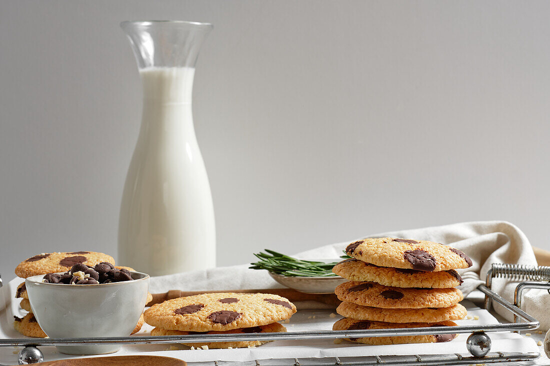 Köstliche hausgemachte süße Kekse mit Schokoladenschiffen, serviert auf einem Tablett mit einem Glas Milch