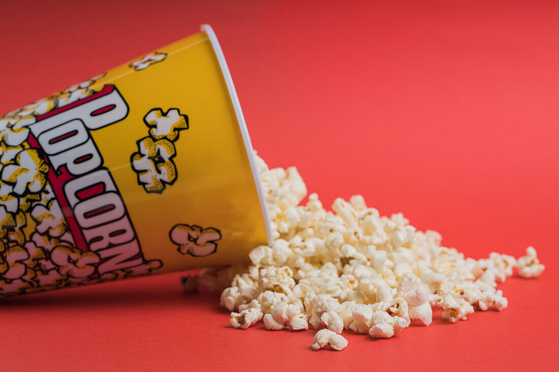Schale mit Popcorn auf rotem Hintergrund