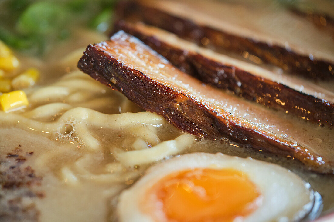 Stockfoto von leckerer Ramen-Suppe mit gekochtem Ei und Fleisch in einem japanischen Restaurant