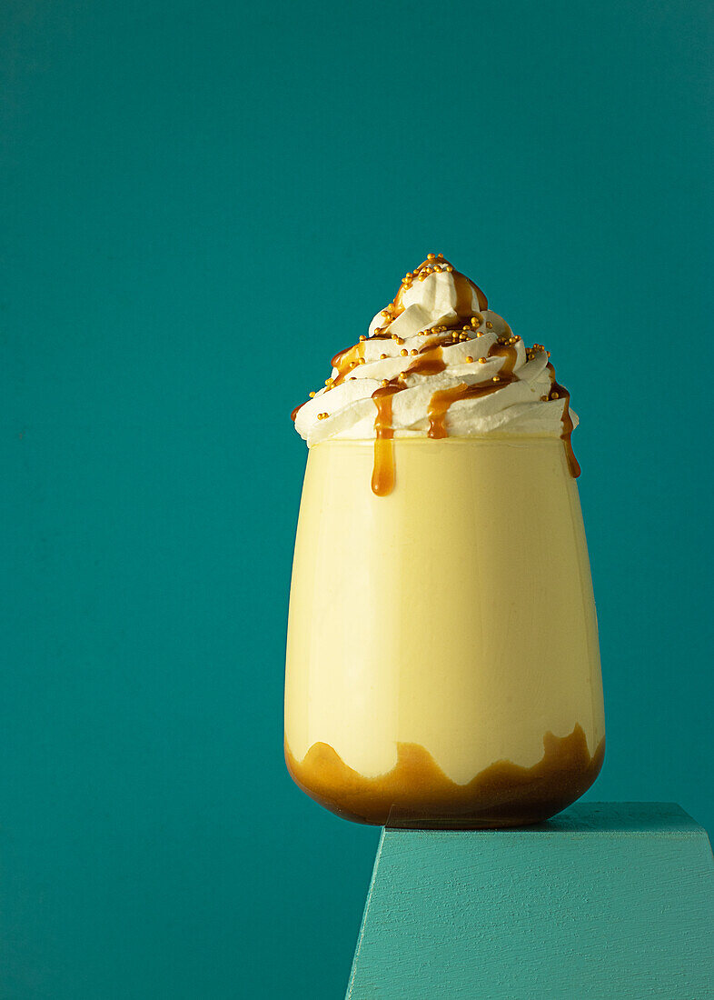 Salted caramel frappe coffee served on glass at colorful blue background