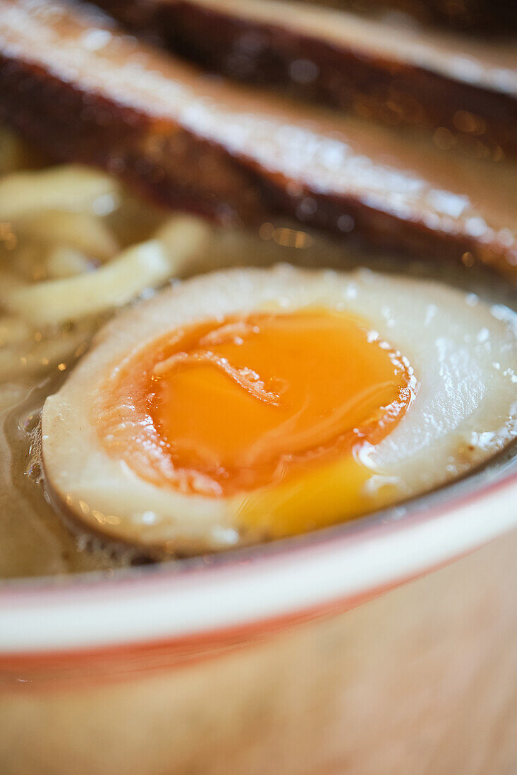 Stockfoto von leckerer Ramen-Suppe mit gekochtem Ei und Fleisch in einem japanischen Restaurant