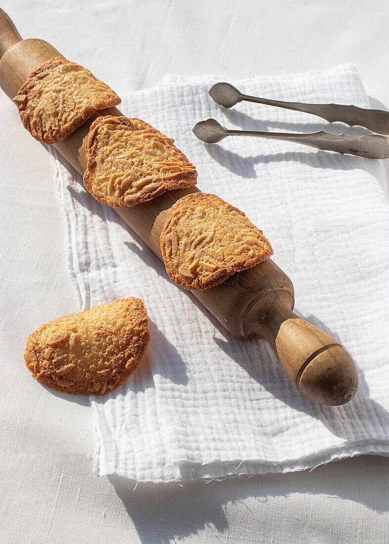 Top view of delicious Almond Tiles cookies placed on plate on tablecloth