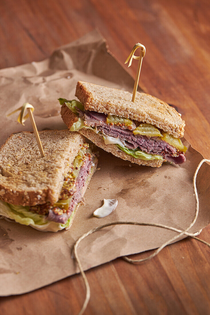 Closeup of a delicious pastrami, lettuce, ham and pickle sandwich