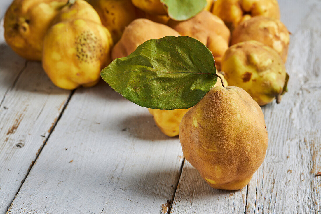 Fresh whole sour yellow lemons on white wooden background