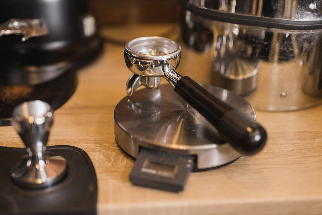 Portafilter for grinding coffee beans near tamper for making fresh espresso in coffee shop