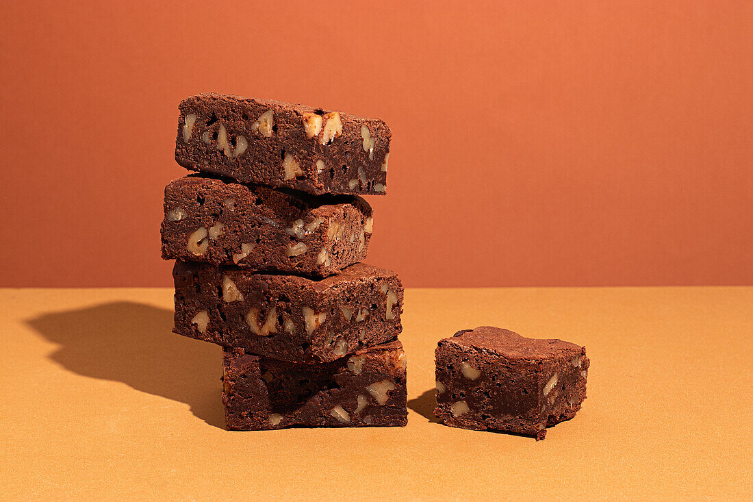 Composition of little stack of tasty sweet brownie yellow and orange background