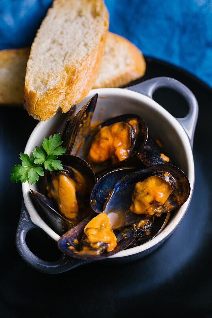 Delectable mussels with herbs in metal saucepan