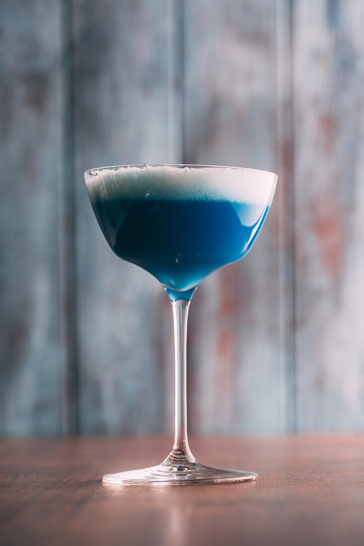 Blue cocktail on a wooden table