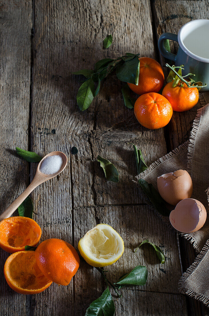 Von oben: Verschiedene Zutaten für Mandarinenmousse auf einem Holztisch in der Küche