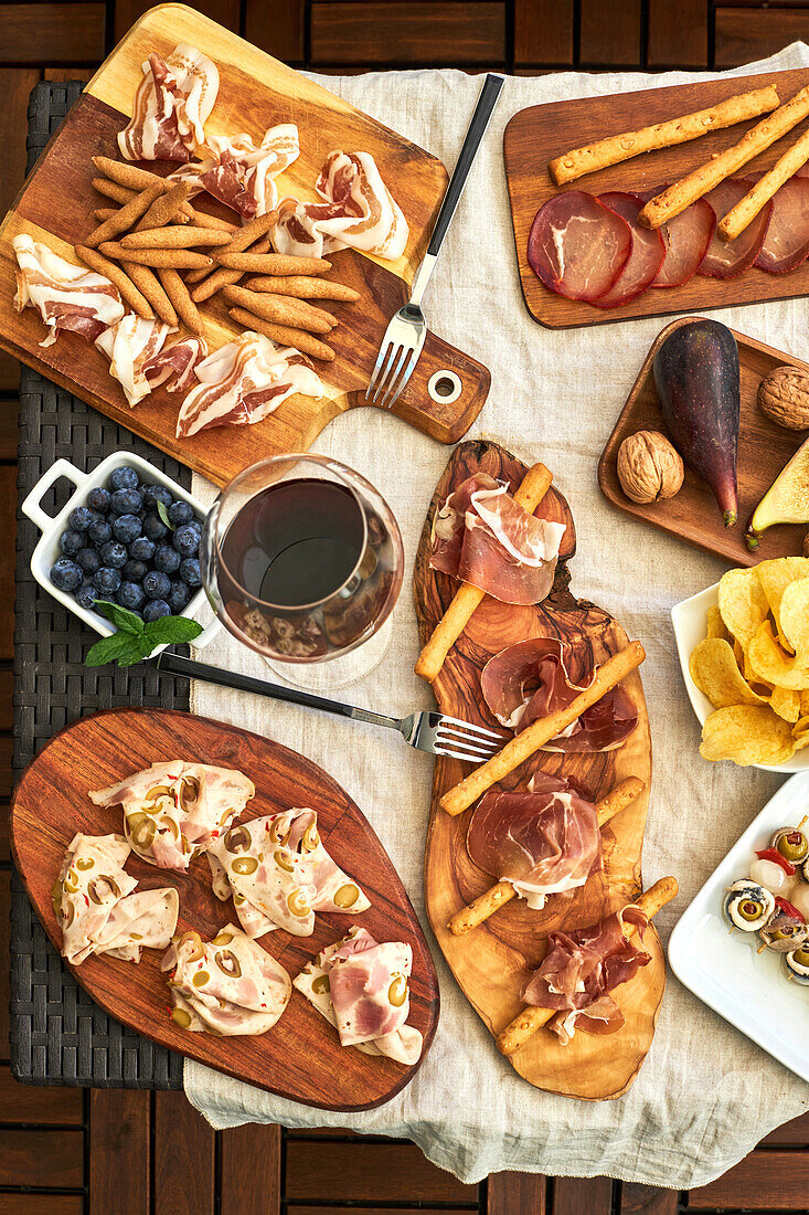 Top view of appetizing antipasto assortment served with plates on table on terrace