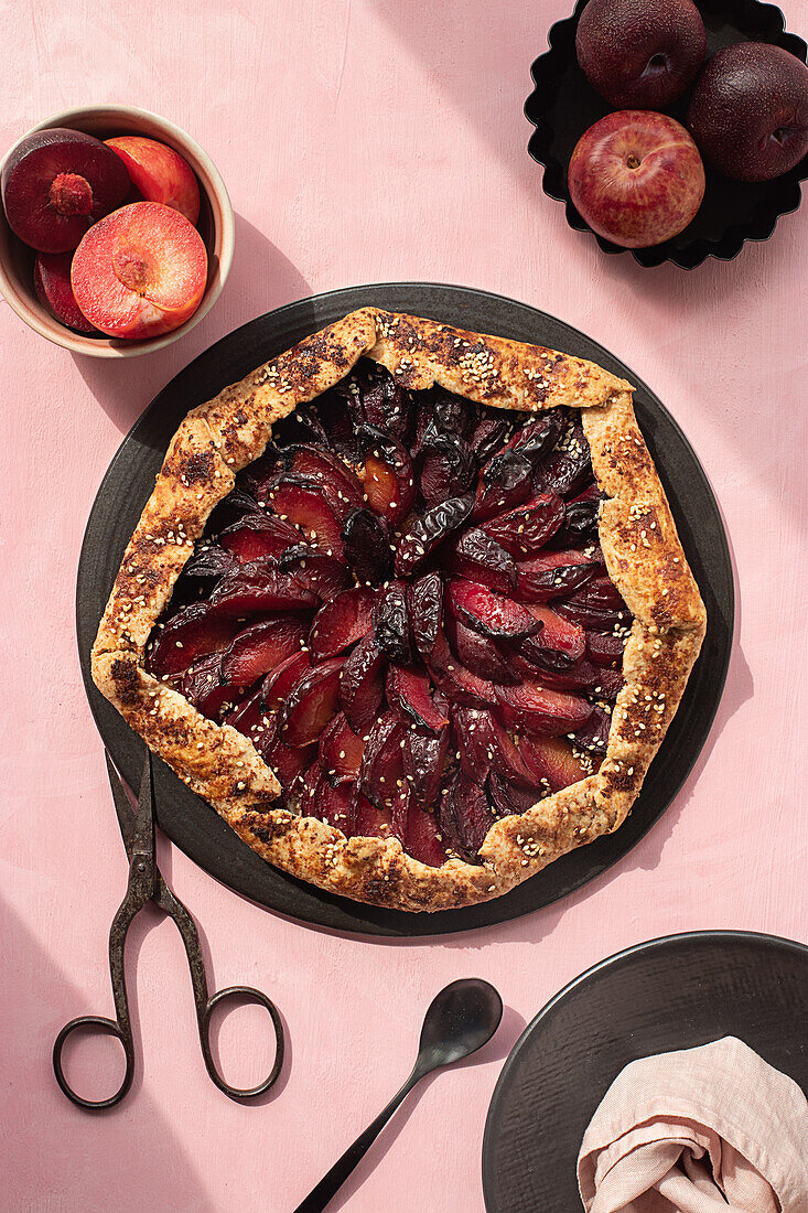 Close-up of a plum cake seen from above on a pink background