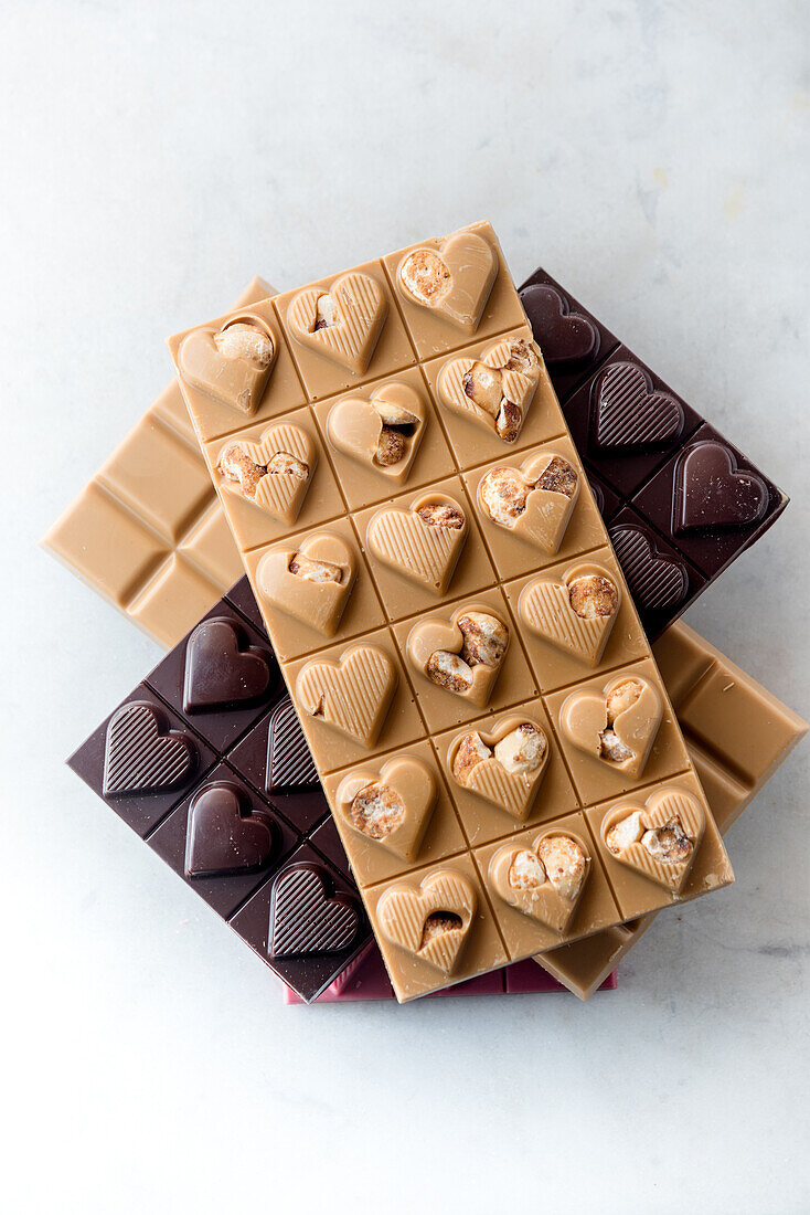 Draufsicht auf köstliche Schokoladenbonbons mit Nüssen in Herzform auf weißem Hintergrund