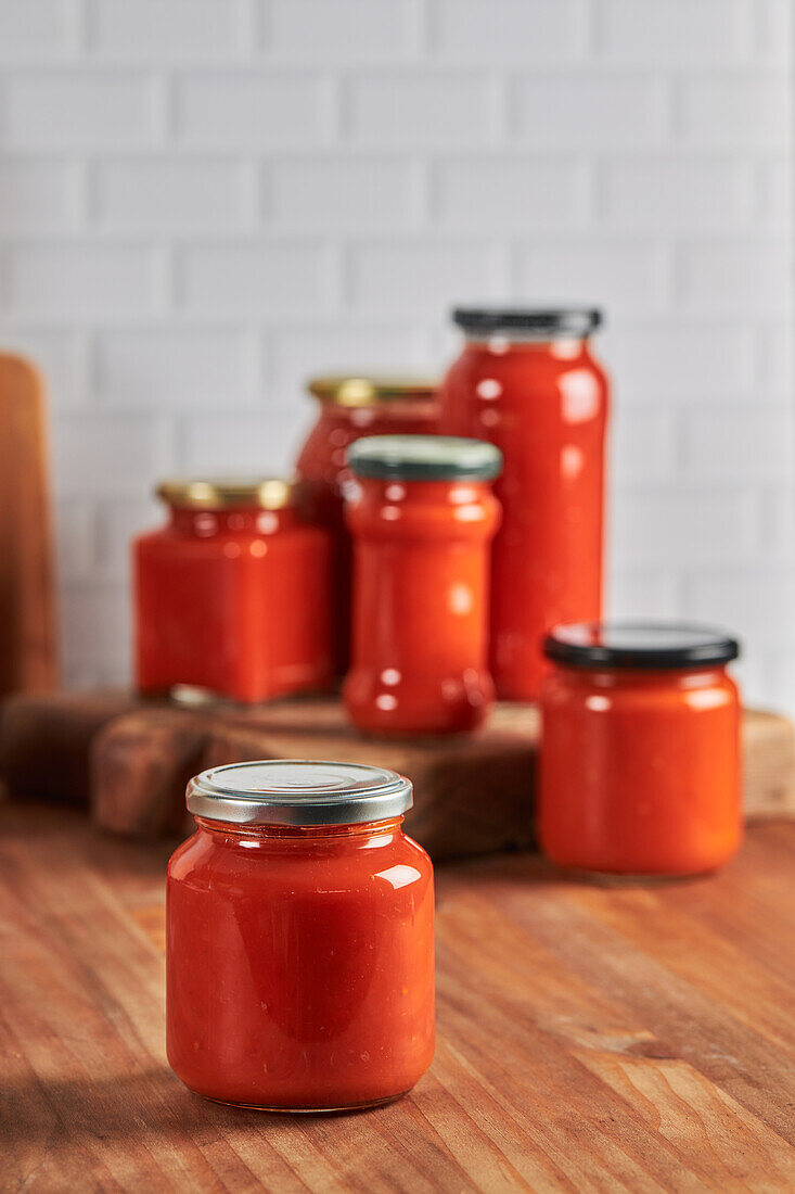 Verschlossenes Glas mit handgemachter Tomatensauce auf dem Tisch in der Küche zu Hause