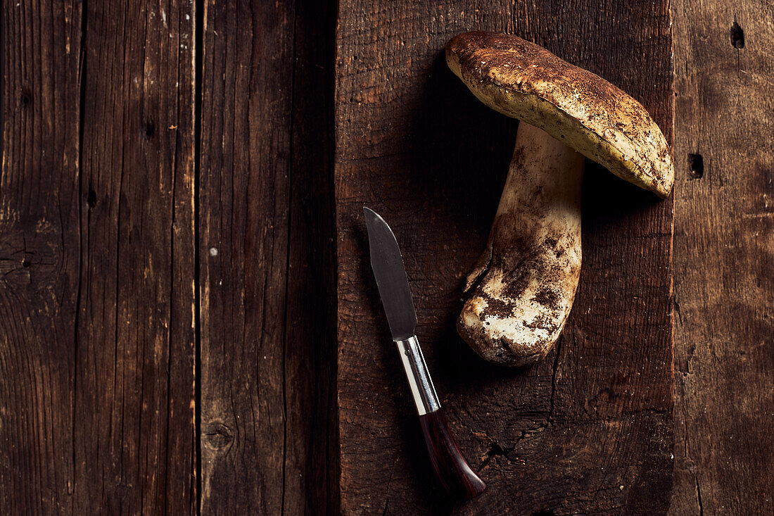 Top view of raw cut Boletus edulis mushrooms on rustic wooden chopping board during cooking process