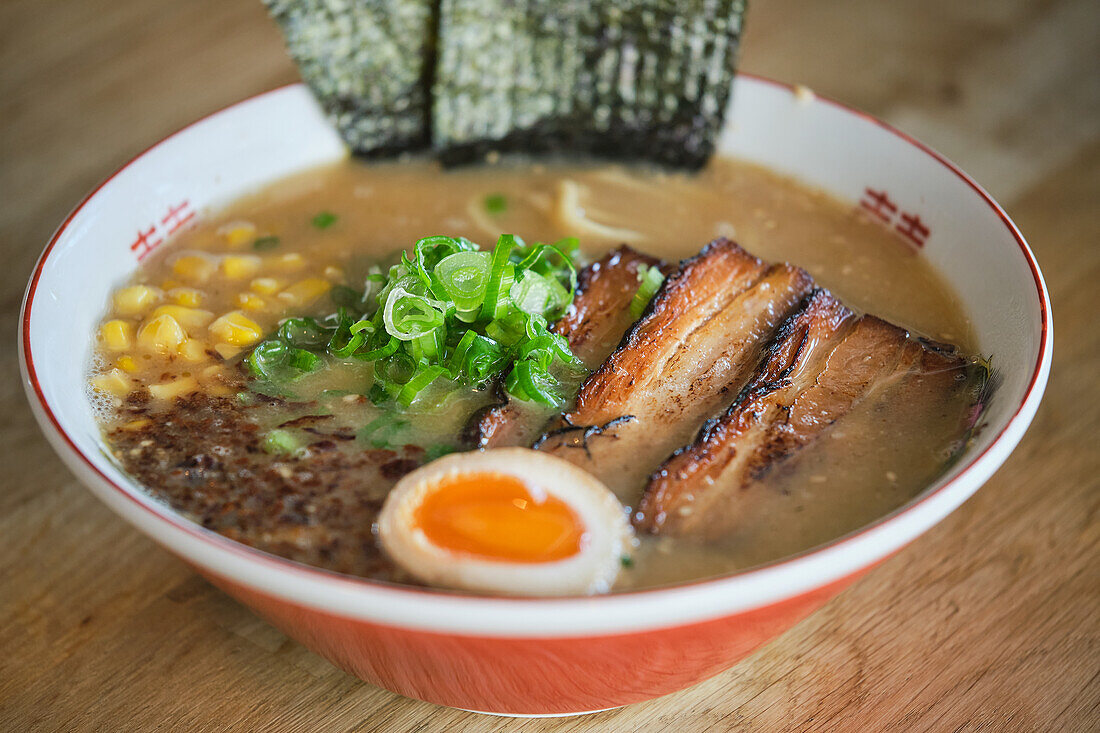 Stockfoto von leckerer Ramen-Suppe mit gekochtem Ei und Fleisch in japanischem Restaurant