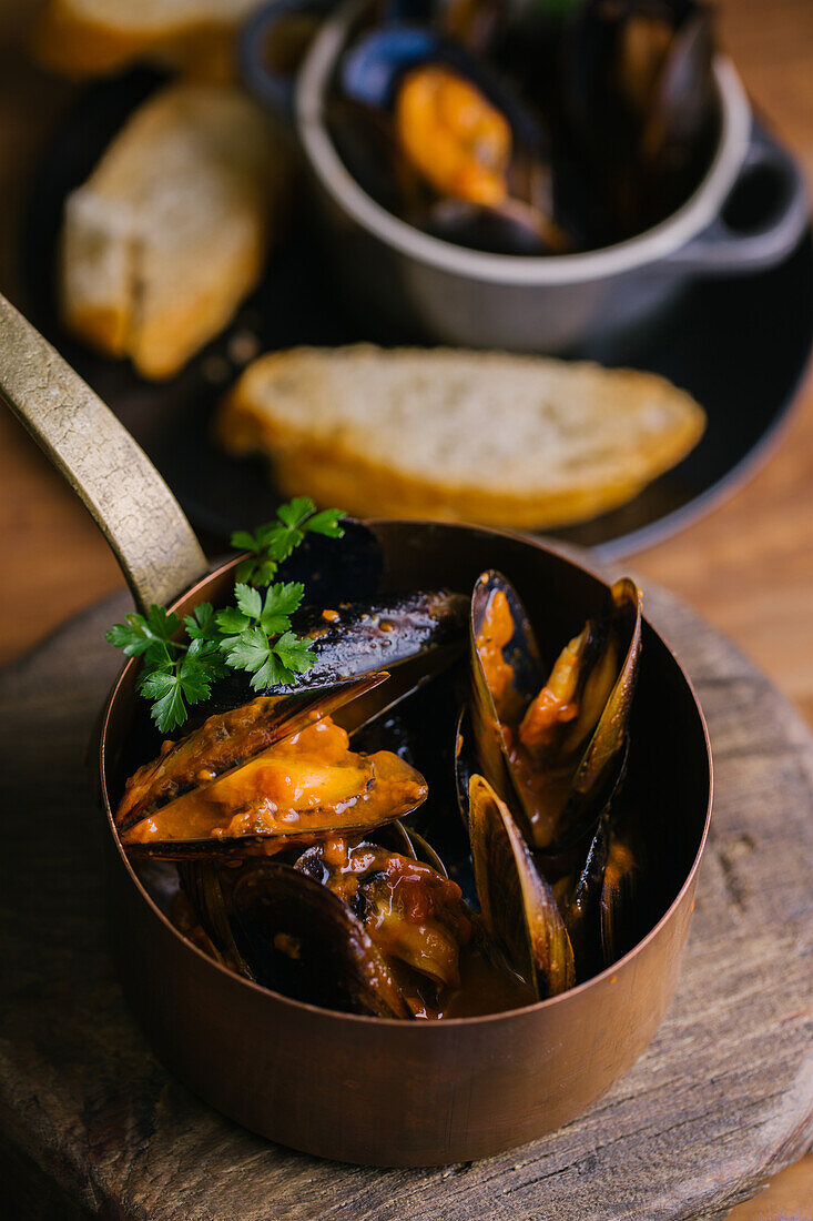 Delectable mussels with herbs in metal saucepan