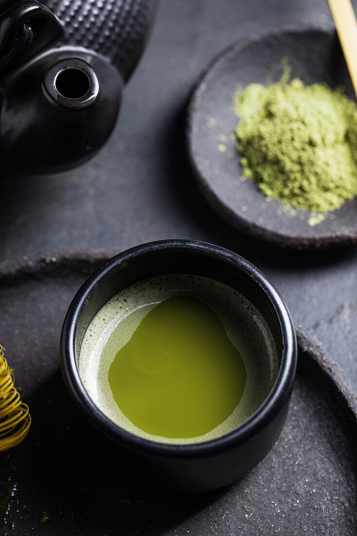 Von oben gesehen traditioneller japanischer Matcha mit Teebesen in einer Steinschale für eine traditionelle orientalische Zeremonie