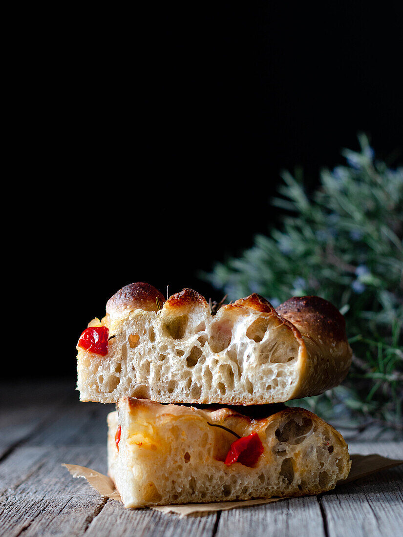 Close up of one piece of fresh tomato focaccia with rosemary
