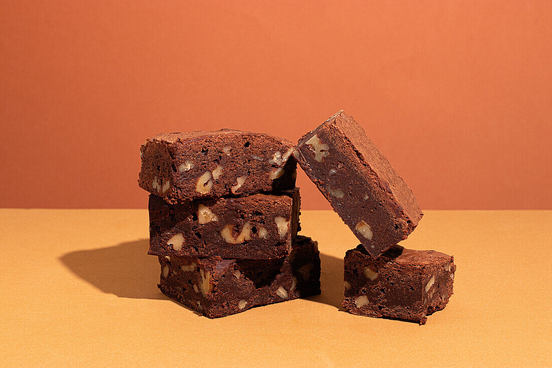 Komposition von kleinen Stapel von leckeren süßen Brownie gelb und orange Hintergrund