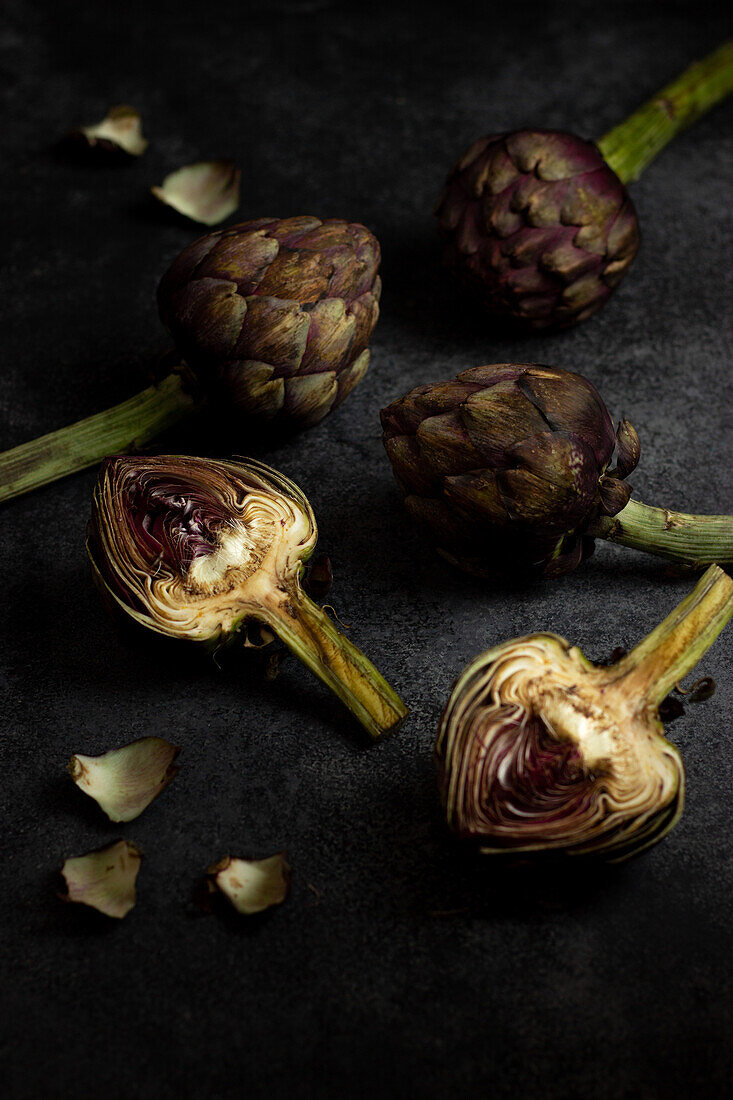 From above ripe green artichokes placed on black table background