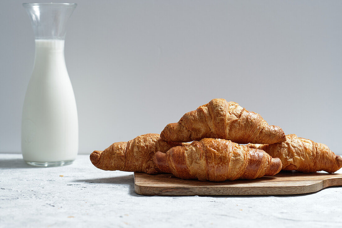 Leckere Croissants und eine Flasche Milch auf dem Frühstückstisch in der Küche