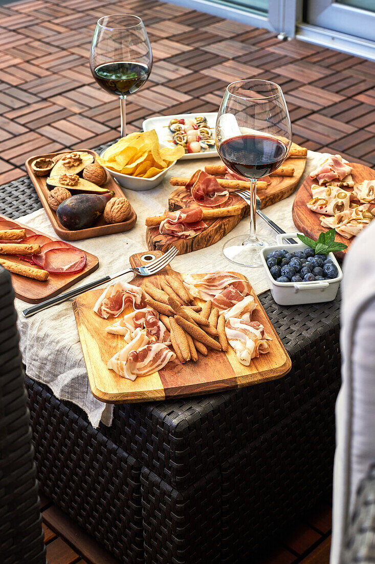 Top view of appetizing antipasto assortment served with plates on table on terrace