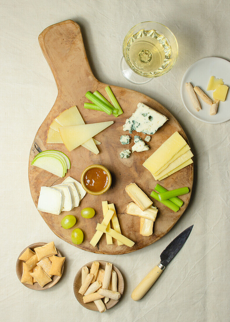 From above various cut cheese on wooden board with croutons placed on table