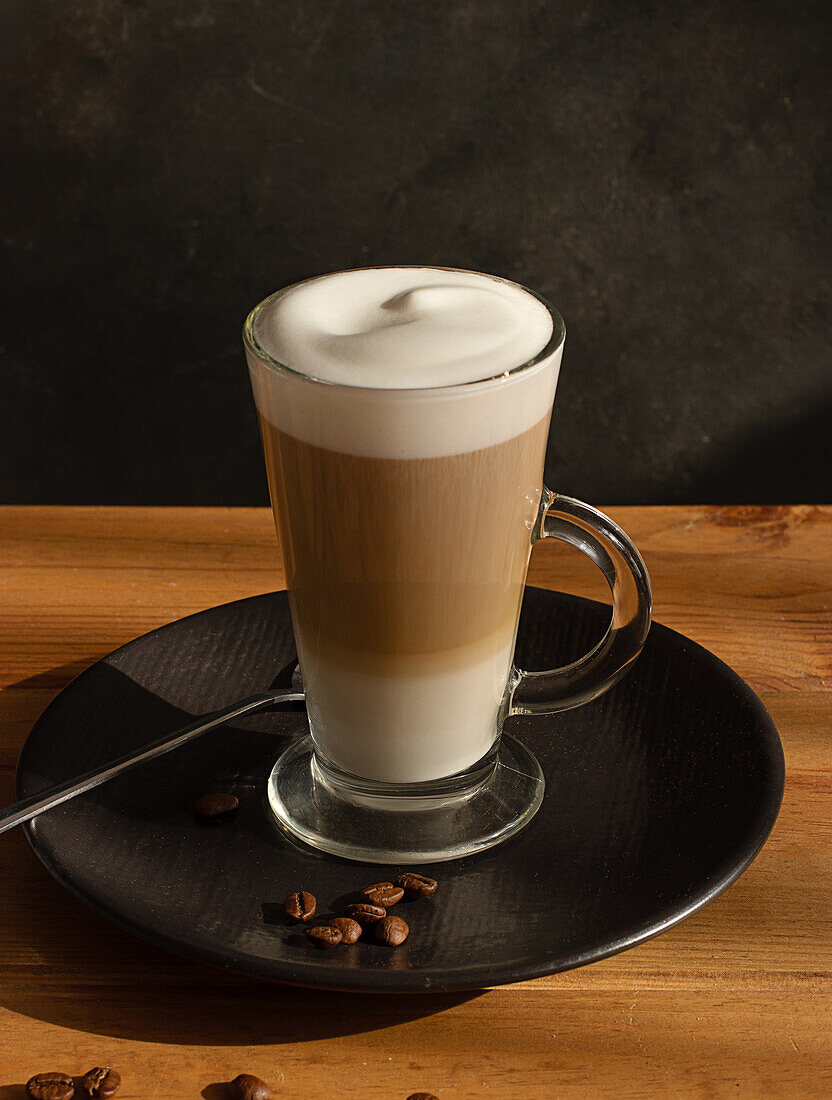 Glass of fresh hot aromatic latte coffee served on table