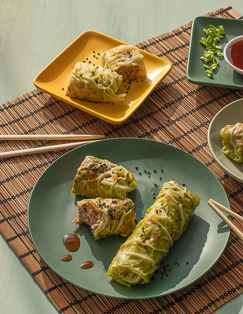 Cabbage spring rolls served on bamboo place mat near chopsticks