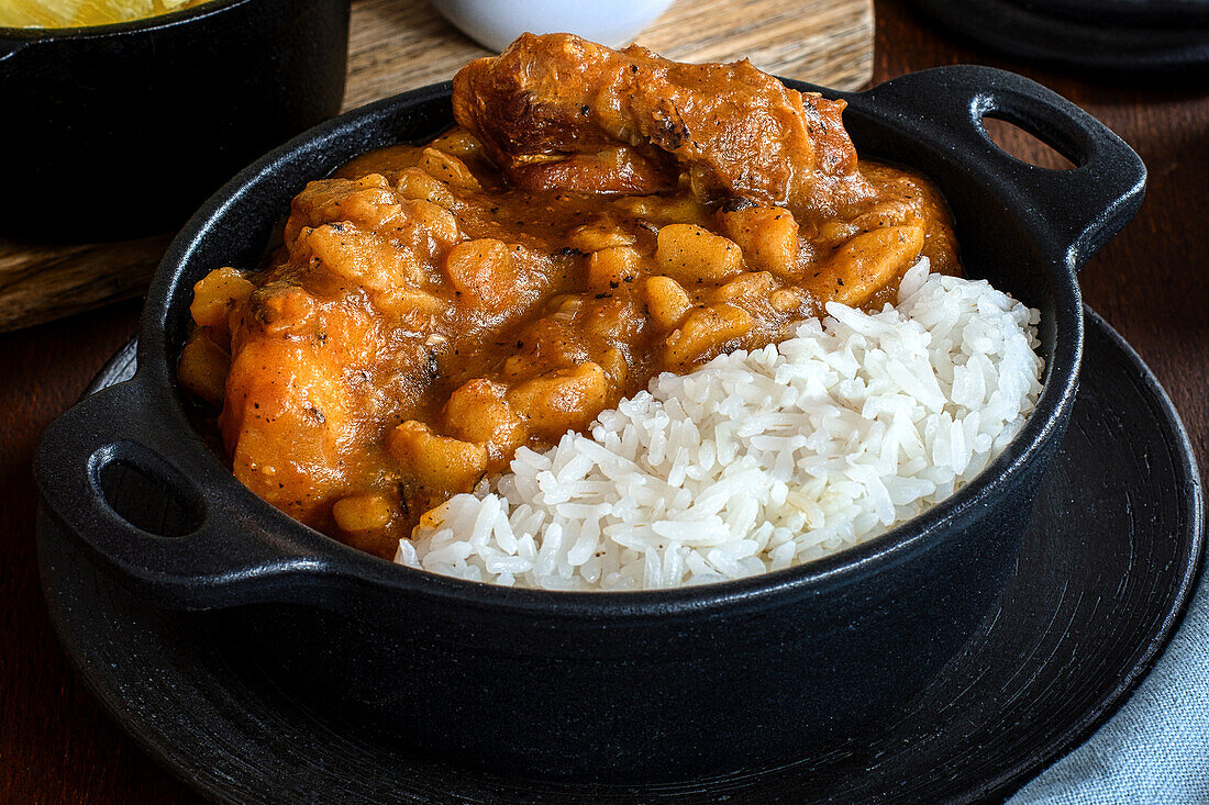 Delicious dish of rice with stew of dehydrated potatoes and meat slices against cooked cassava