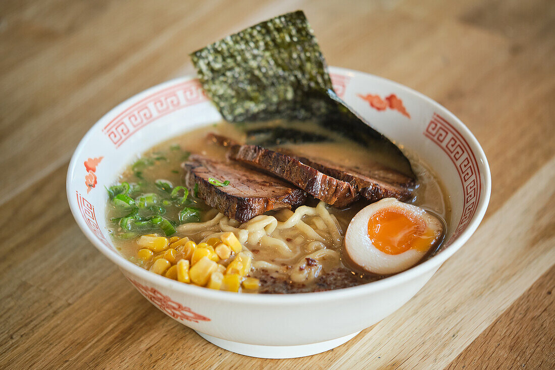 Stock photo of yummy ramen soup with boiled egg and meat in japanese restaurant.