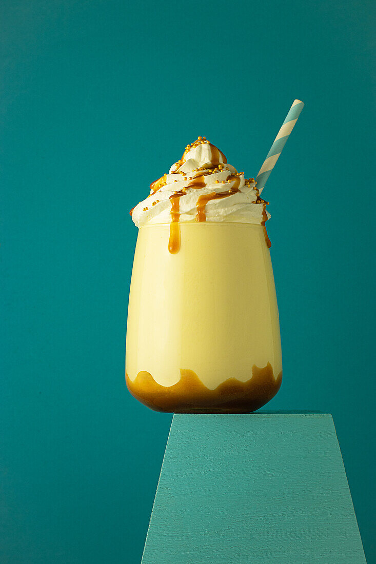 Salted caramel frappe coffee served on glass at colorful blue background