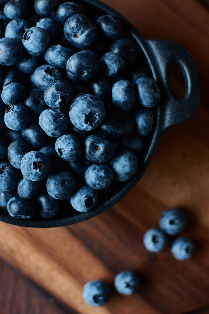 Top view of blueberries in a bowl on the wooden table