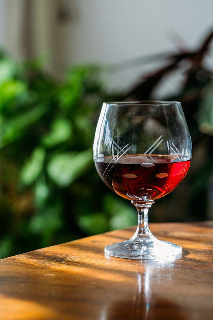 Old fashioned cognac glass on wooden table with natural light