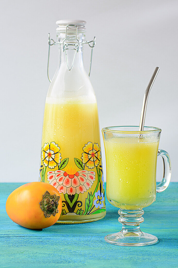 Vorderansicht von Cocona-Saft in einem Glas und einer Glasflasche auf dem Tisch