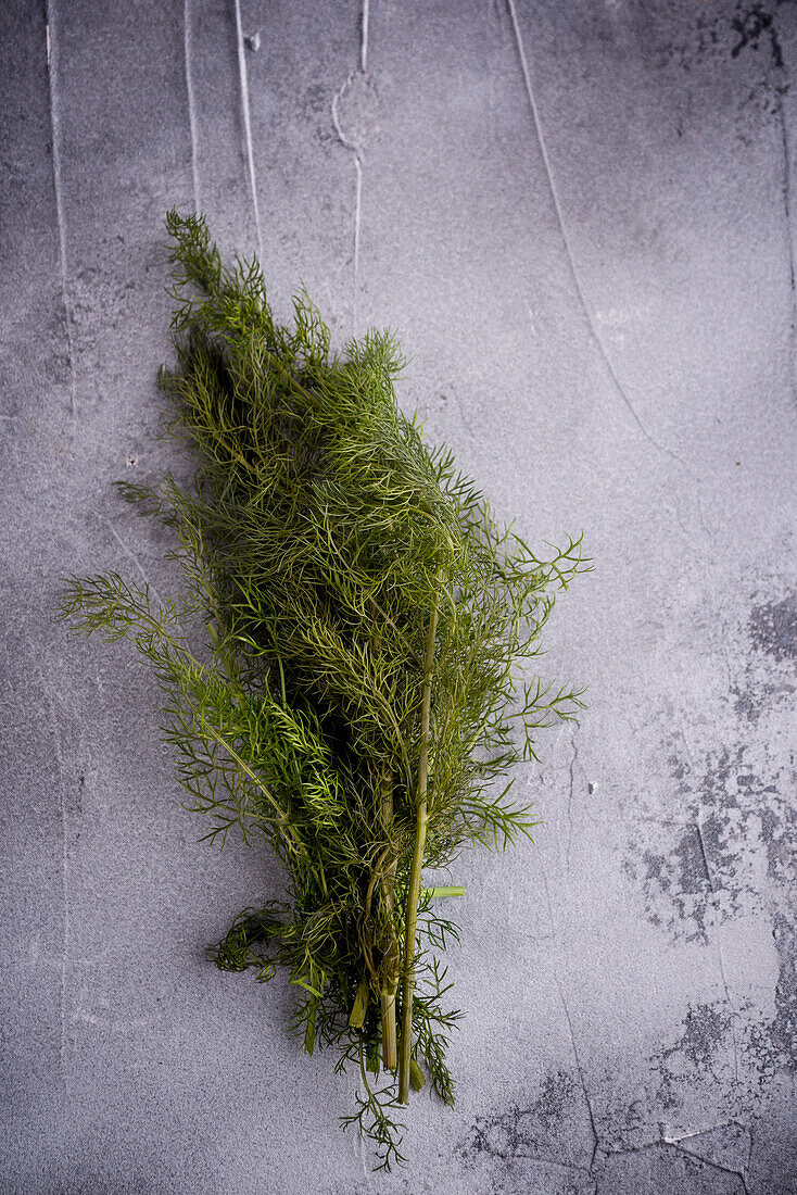 Top view of bundle of aromatic green dill with thin stems on rugged surface