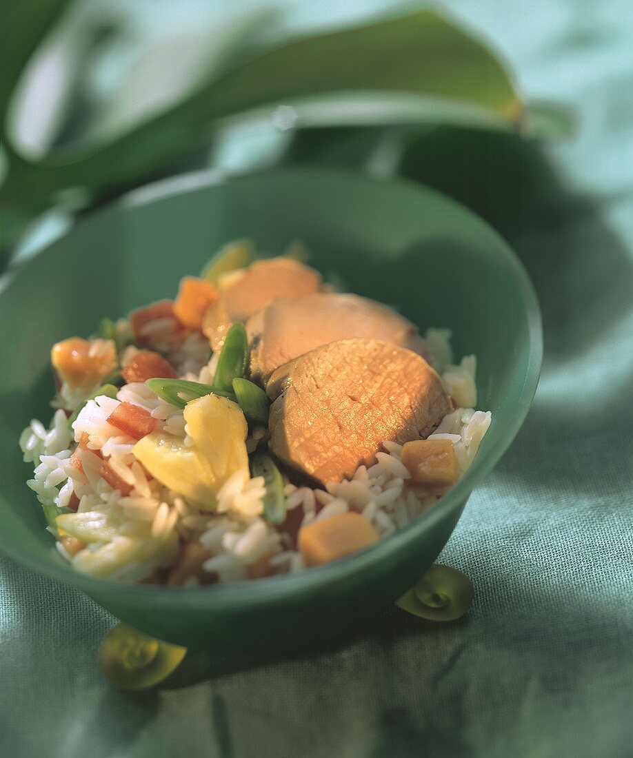 Pork fillet with rice with exotic fruit in bowl