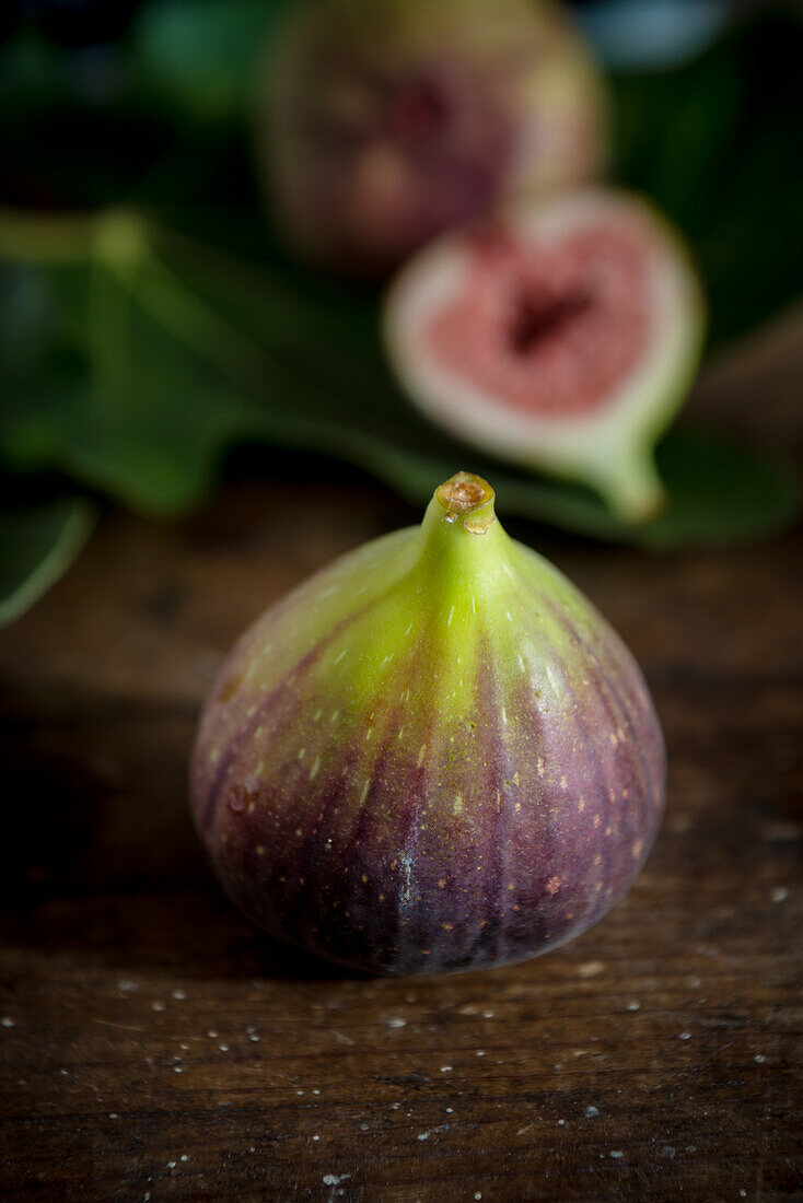 Whole fig with juicy pulp on wooden surface