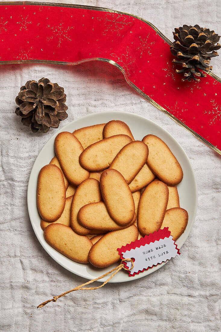 Top view of pile of delicious Christmas cookies placed on plate on tablecloth for holiday celebration