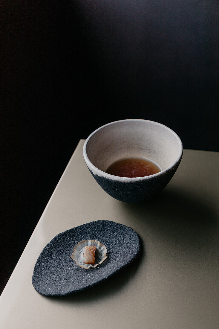 From above of porcelain bowl with soy sauce and gourmet fish in restaurant