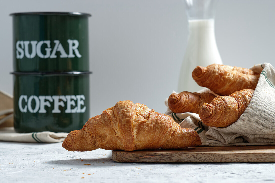 Delicious croissants and bottle of milk placed on table for breakfast in kitchen