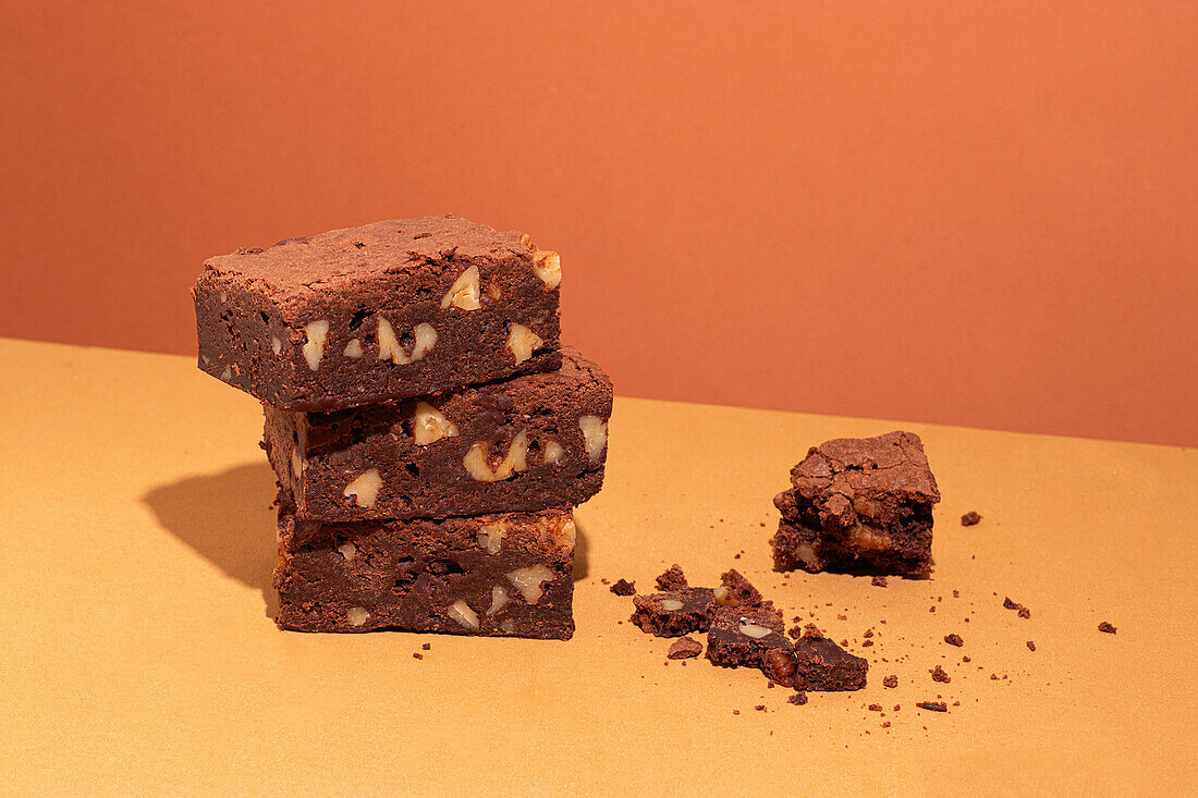 Composition of little stack of tasty sweet brownie yellow and orange background