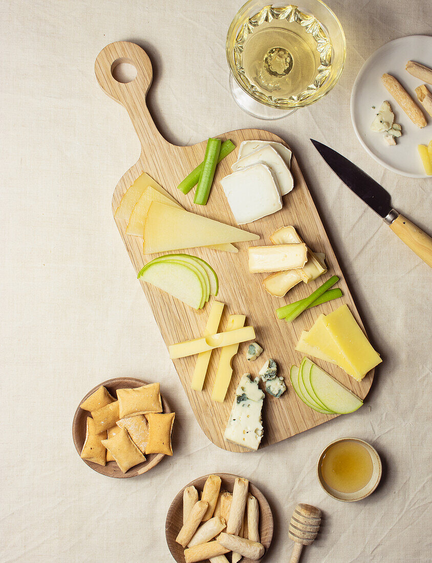 From above various cut cheese on wooden board with croutons placed on table