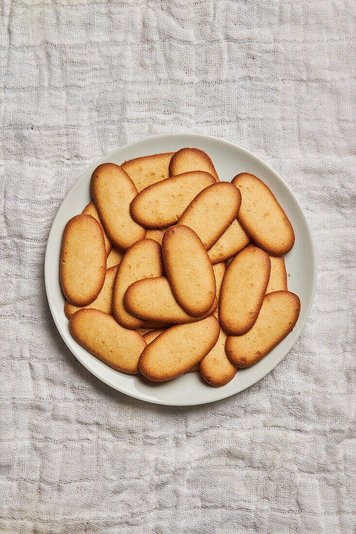 Top view of pile of delicious Christmas cookies placed on plate on tablecloth for holiday celebration