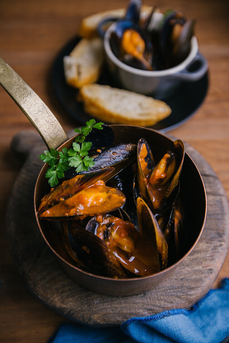 Köstliche Muscheln mit Kräutern in einem Metalltopf