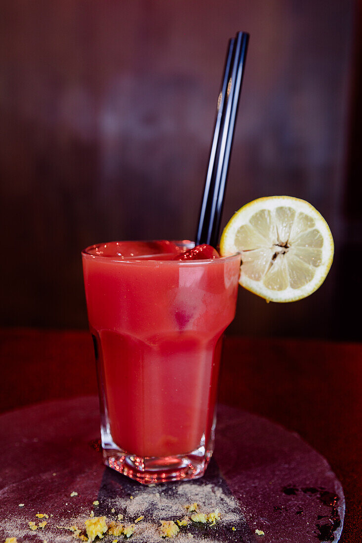 Glas Bloody-Mary-Cocktail aus Wodka und Tomatensaft, serviert mit einer Zitronenscheibe