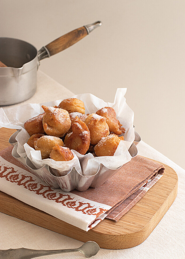 Von oben frittierter Beignets-Krapfen auf Holztablett auf Tisch in Küche