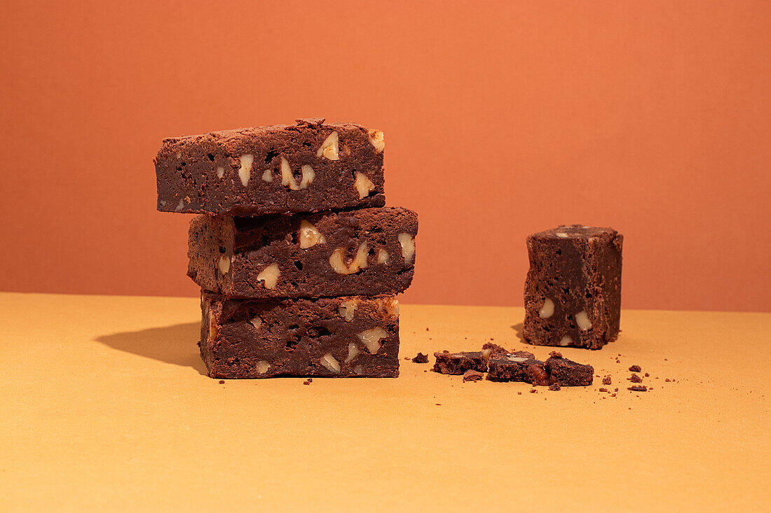 Composition of little stack of tasty sweet brownie yellow and orange background